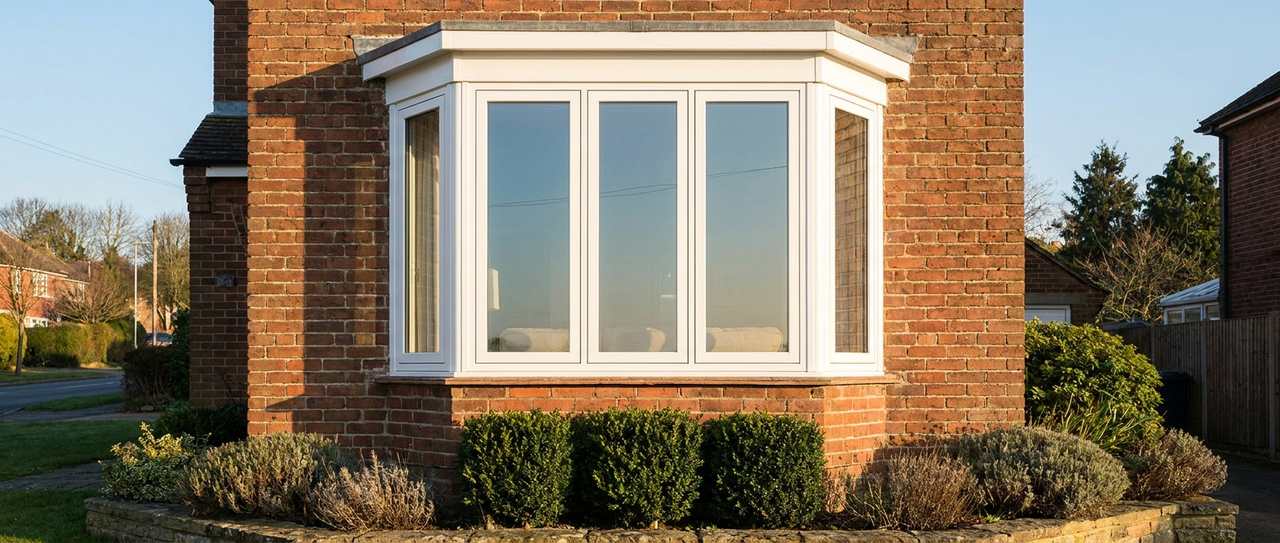 Exterior of a brick home with a white bay window projecting from the facade